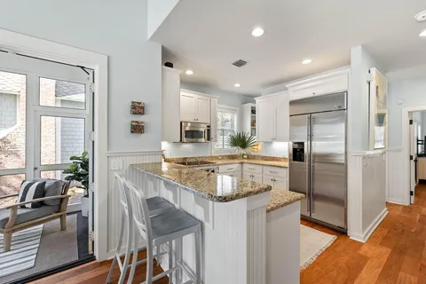 a kitchen with kitchen island granite countertop a refrigerator stove microwave and sink