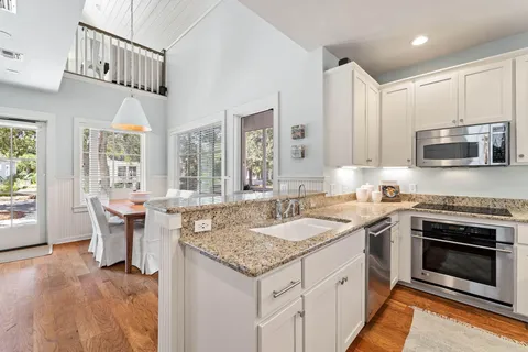 a kitchen with granite countertop a stove sink and microwave