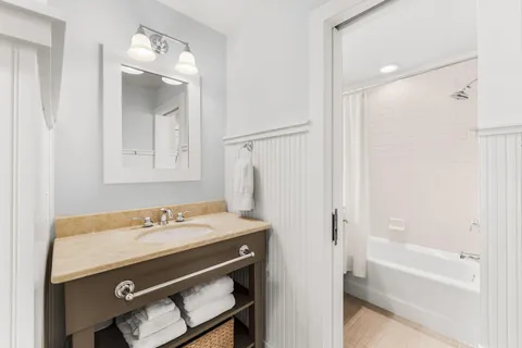 a bathroom with a sink a mirror a vanity and a shower