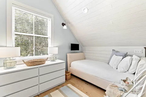 a front view of a house with a yard and potted plants