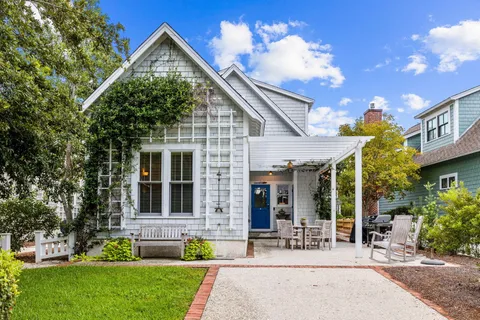 a front view of a house with a yard and potted plants