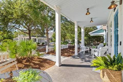 a view of a porch with chairs and potted plants
