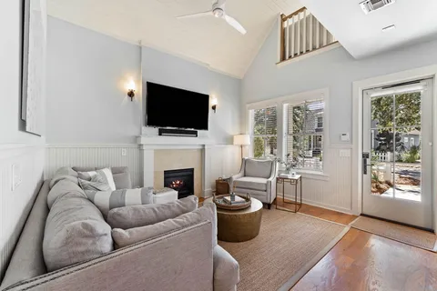 a living room with furniture a flat screen tv and a fireplace