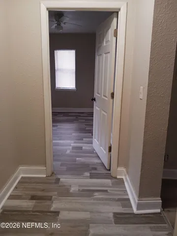 a view of a hallway with wooden floor and staircase
