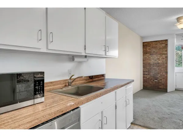 a kitchen with cabinets and wooden floor