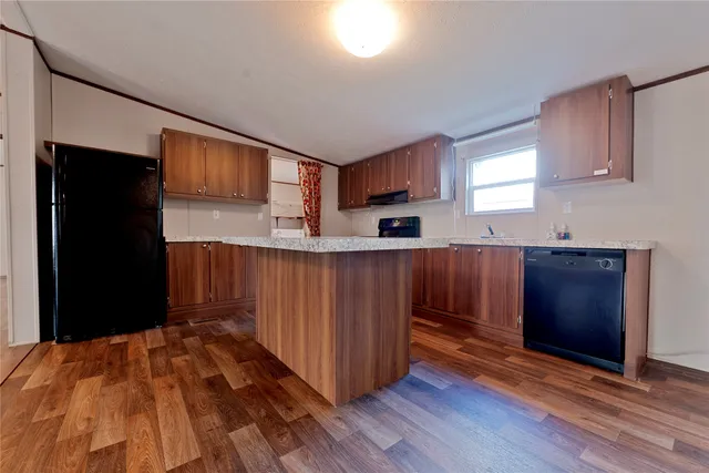 a kitchen with stainless steel appliances granite countertop a refrigerator and a wooden cabinets