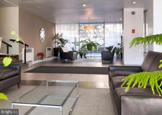 a lobby with furniture and potted plants