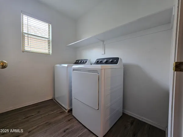 a view of a hallway with wooden floor and a bathroom