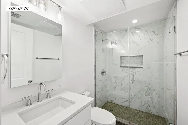 a bathroom with a granite countertop sink toilet and shower