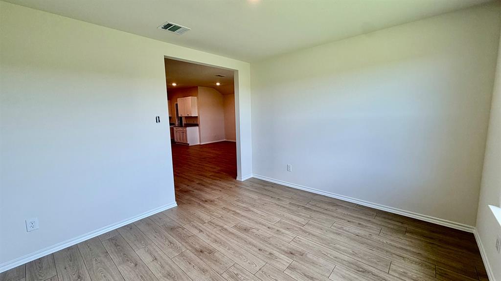 2003 Reveille Way Terrell, TX 75160 - Photo 17 of 25 Spacious room featuring wood-finish flooring, white baseboards, and neutral wall paint