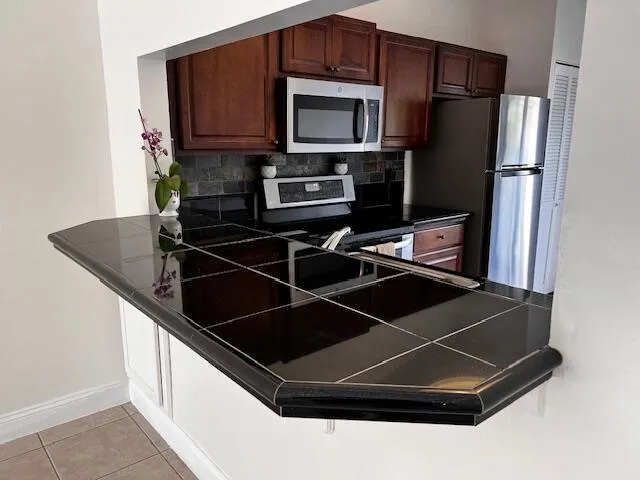 a kitchen with a sink a microwave a refrigerator and cabinets