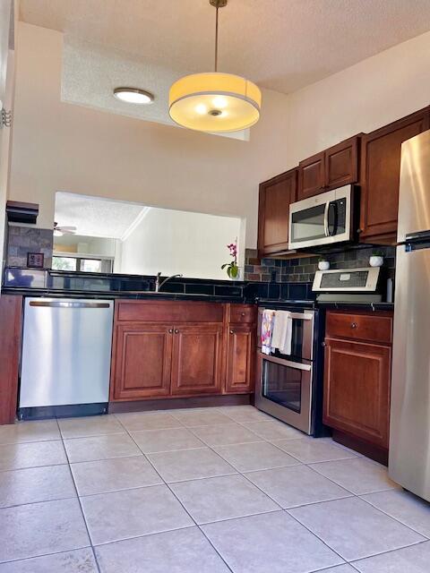 10323 Boca Bend West, Unit K4 Boca Raton, FL 33428 - Photo 6 of 25 a kitchen with stainless steel appliances granite countertop a stove microwave and sink