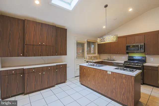 a kitchen with stainless steel appliances a refrigerator and a stove top oven