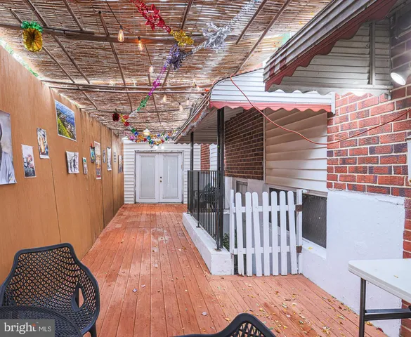a backyard of a house with plants and large tree
