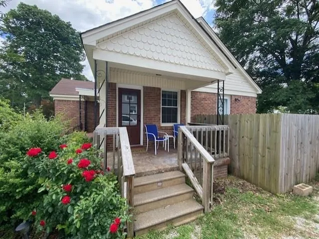 a view of a house with wooden fence and garden