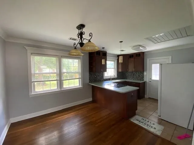 a kitchen with granite countertop a sink cabinets stainless steel appliances and a window