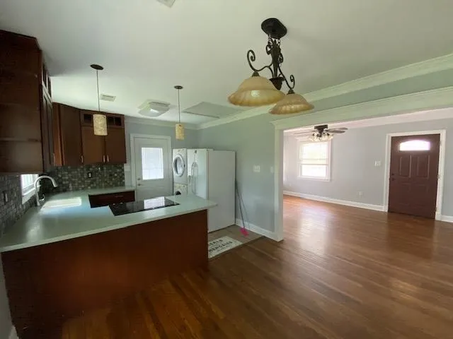 a kitchen with stainless steel appliances granite countertop a sink a stove and a wooden floor