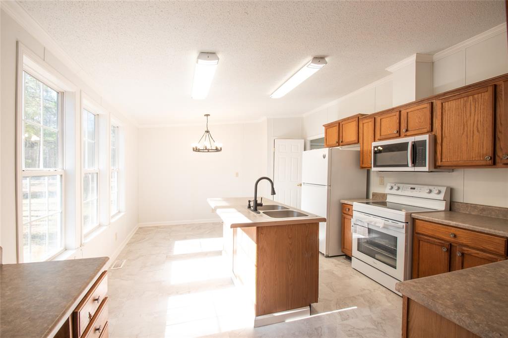 128 Fob Lane Frierson, LA 71027 - Photo 7 of 22 a kitchen with stainless steel appliances granite countertop a sink stove and refrigerator