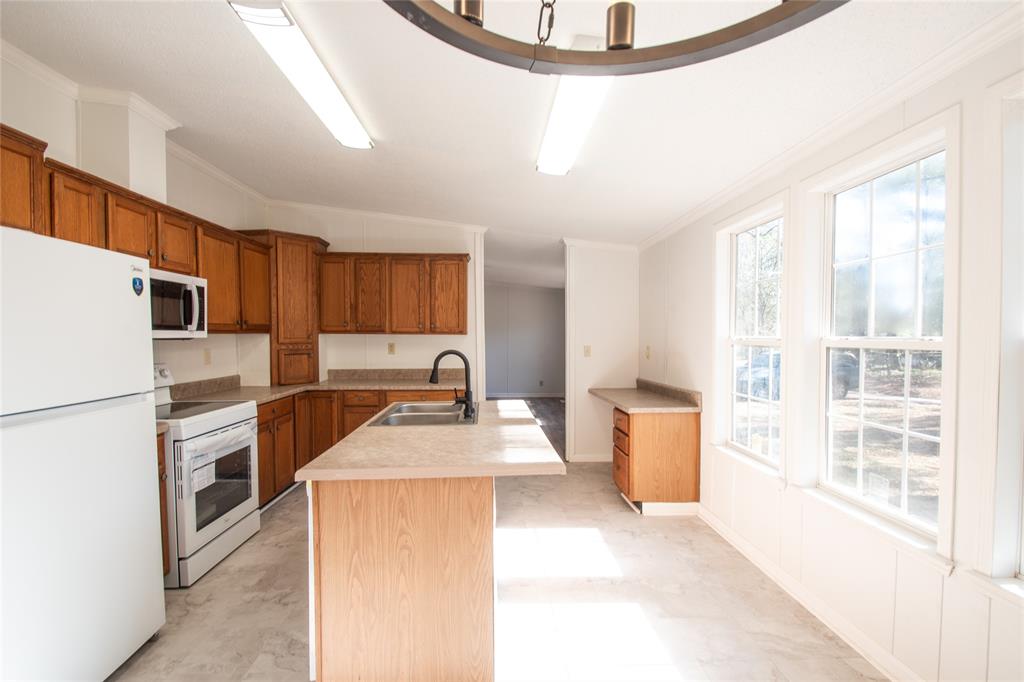 128 Fob Lane Frierson, LA 71027 - Photo 9 of 22 a kitchen with a refrigerator a stove and wooden floor
