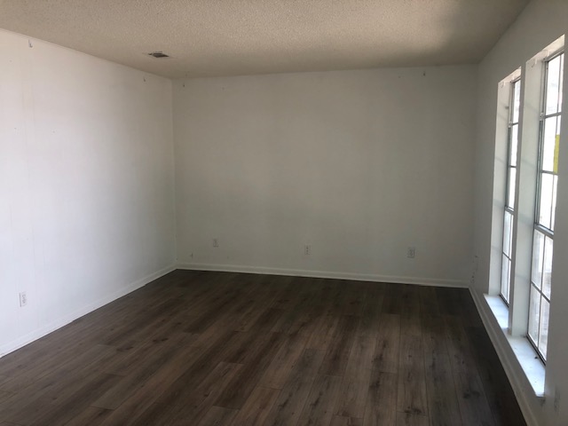 404 West Dittmar Road Austin, TX 78745 - Photo 3 of 15 Empty room featuring a textured ceiling and dark wood-type flooring
