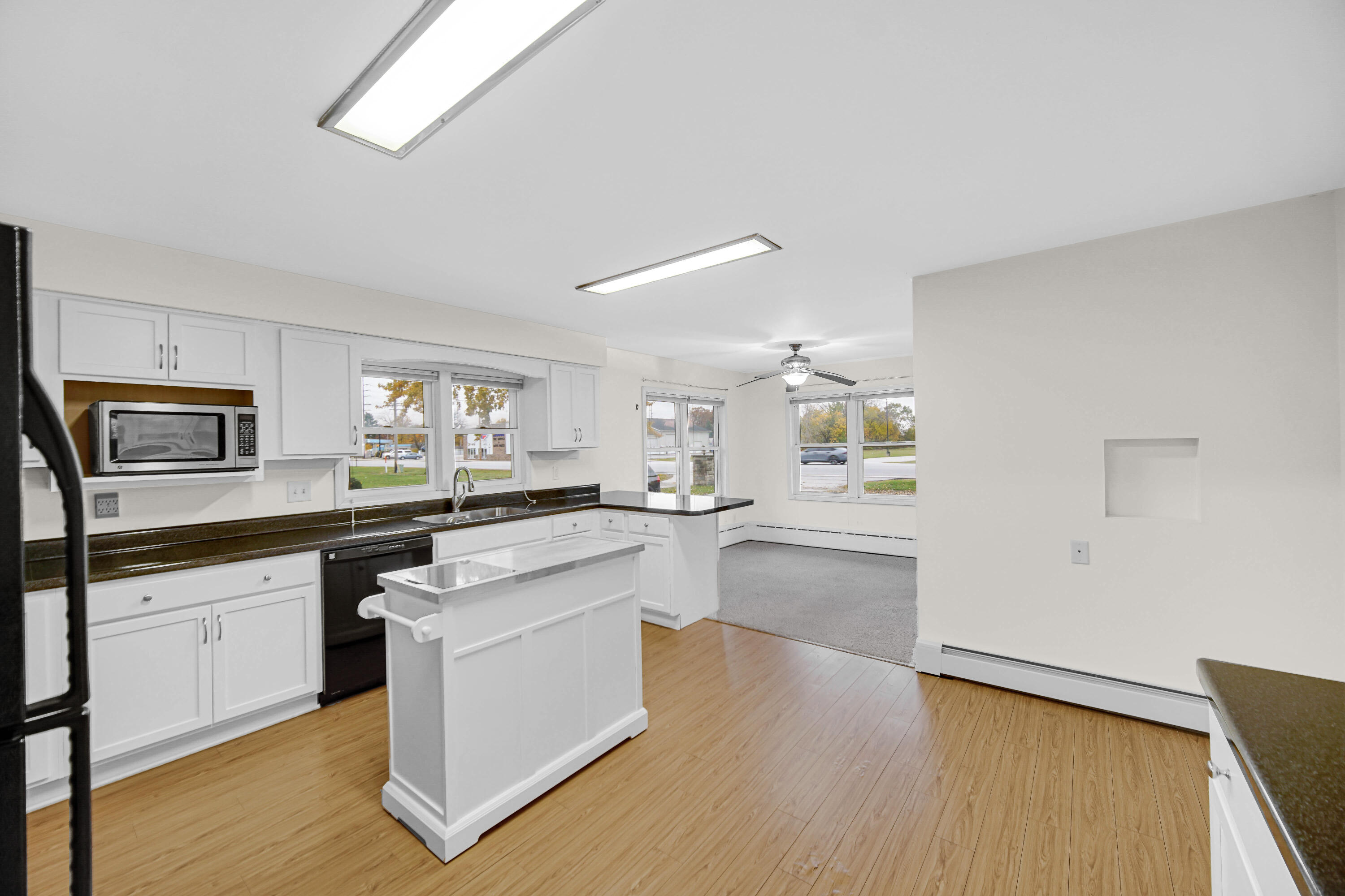 204 North Main Street Kouts, IN 46347 - Photo 11 of 28 a large kitchen with cabinets wooden floor and stainless steel appliances