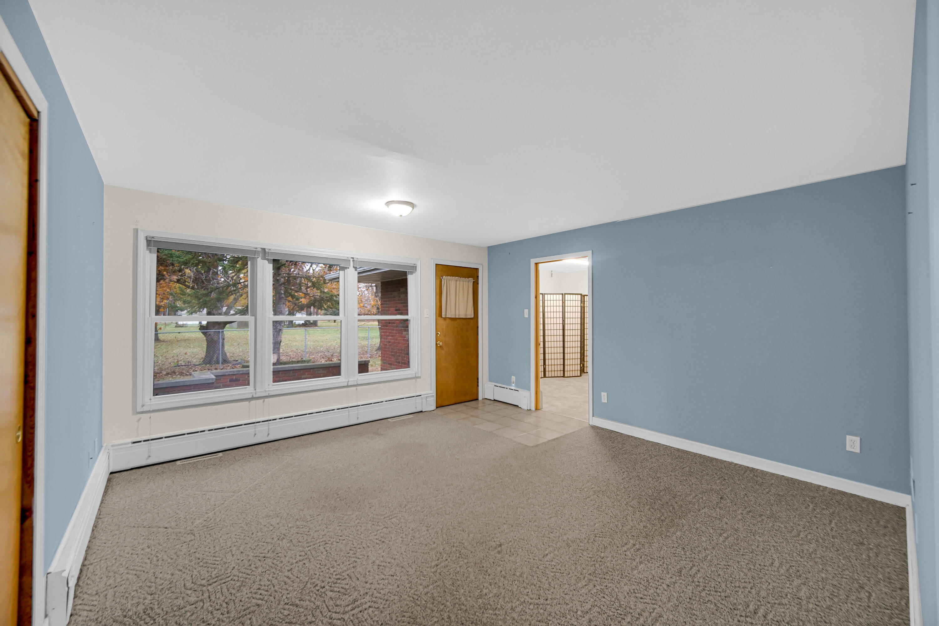 204 North Main Street Kouts, IN 46347 - Photo 17 of 28 an empty room with a fireplace and large window