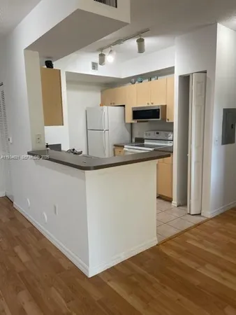 a kitchen with stainless steel appliances granite countertop a sink and a refrigerator