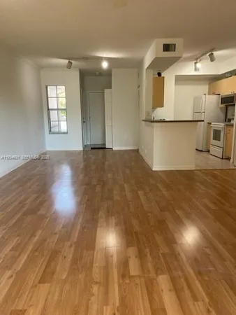 a view of a kitchen with wooden floor and a window