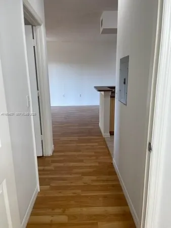 a view of a hallway with wooden floor and staircase