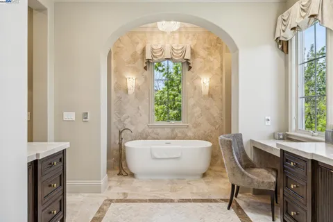 a spacious bathroom with a bathtub sink and mirror