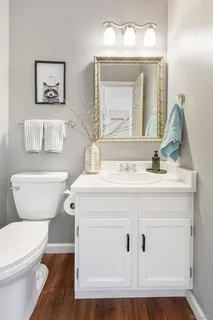 a bathroom with a toilet a sink and mirror