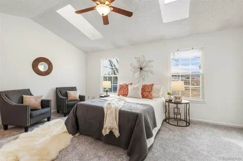 a bedroom with bed a chandelier and a window