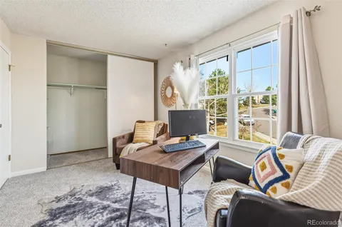 a view of a workspace with furniture and a window
