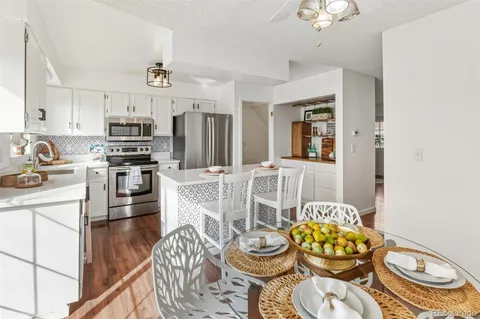 a kitchen with stainless steel appliances a dining table and chairs