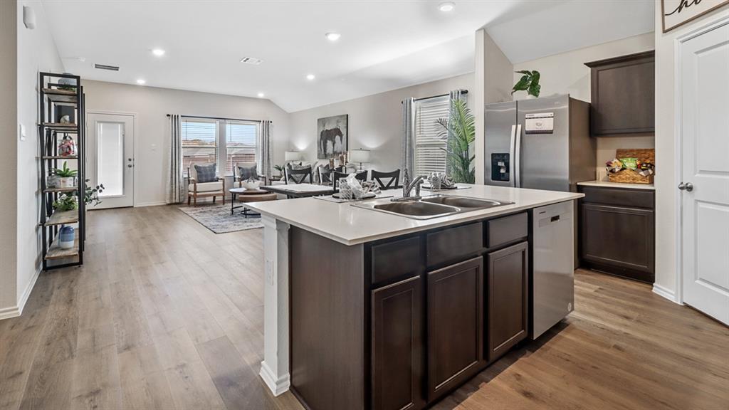 1667 Mantle Road Crandall, TX 75114 - Photo 2 of 20 Kitchen island featuring a double-basin sink, stainless steel dishwasher, and quartz countertop