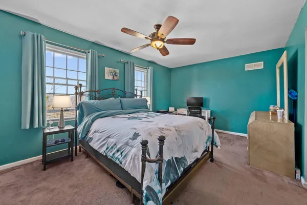 a bedroom with a bed and a large window