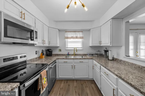 a kitchen with stainless steel appliances granite countertop a sink stove microwave and cabinets