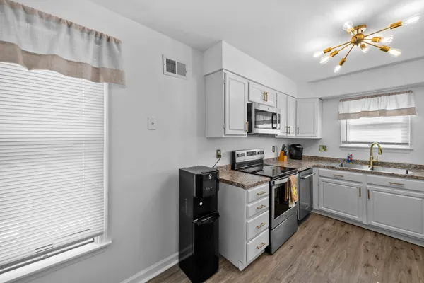 a kitchen with a sink appliances cabinets and a window