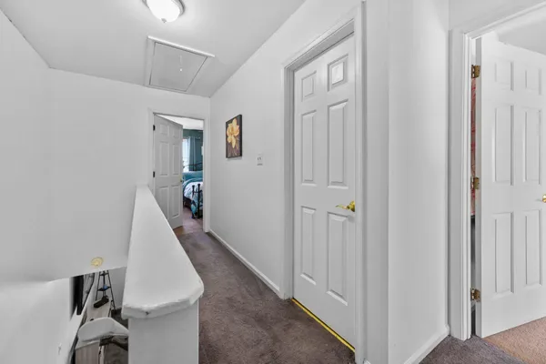 a view of a hallway with white walls and entryway