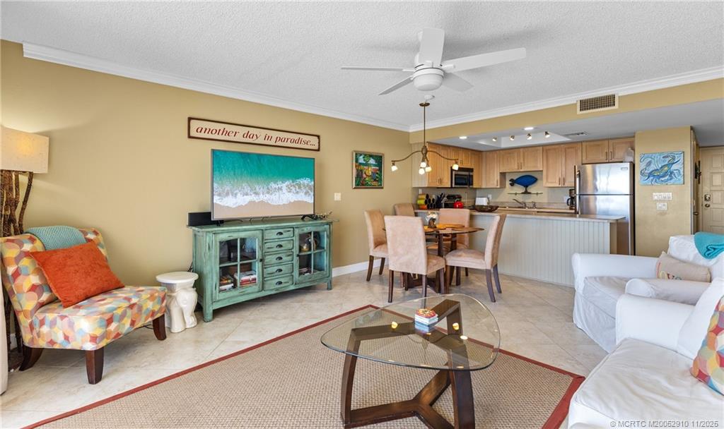 379 Northeast Tradewind Lane, Unit 1104 Stuart, FL 34996 - Photo 13 of 30 a living room with furniture and a flat screen tv