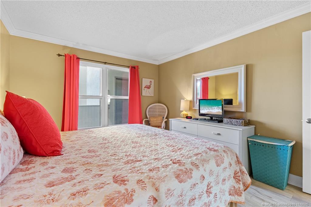 379 Northeast Tradewind Lane, Unit 1104 Stuart, FL 34996 - Photo 20 of 30 a bedroom with a bed and a flat screen tv
