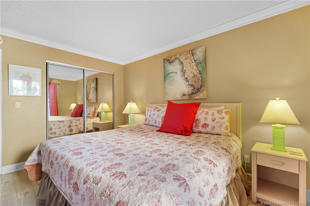 379 Northeast Tradewind Lane, Unit 1104 Stuart, FL 34996 - Photo 21 of 30 a bedroom with a bed and a lamp