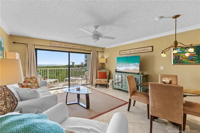 a living room with furniture a flat screen tv and a large window