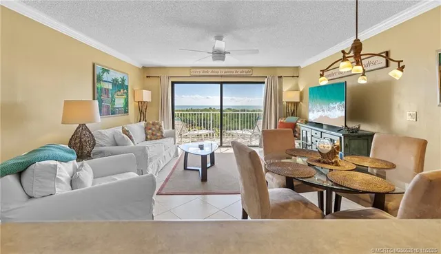 a living room with furniture a flat screen tv and a floor to ceiling window
