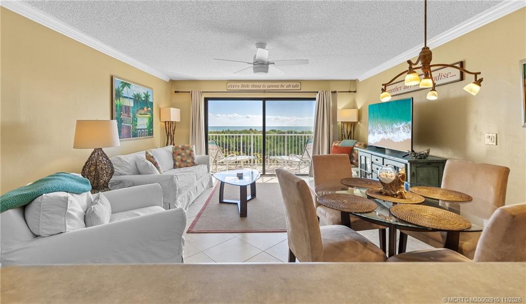 379 Northeast Tradewind Lane, Unit 1104 Stuart, FL 34996 - Photo 10 of 30 a living room with furniture a flat screen tv and a floor to ceiling window