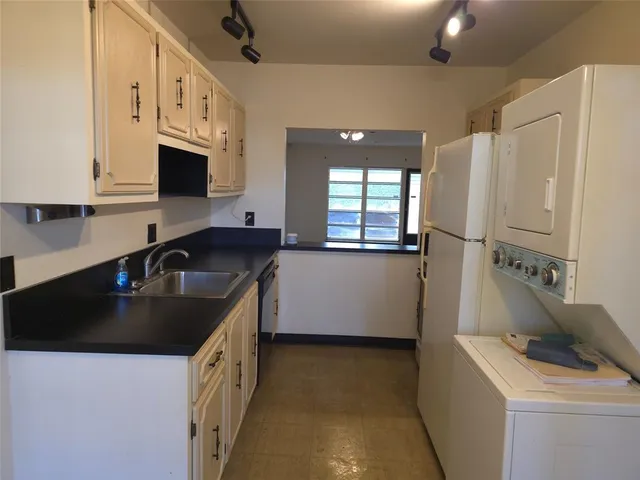 a kitchen that has a sink a stove and a refrigerator