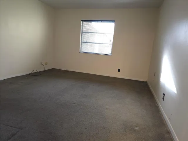 a view of an empty room with closet and a window