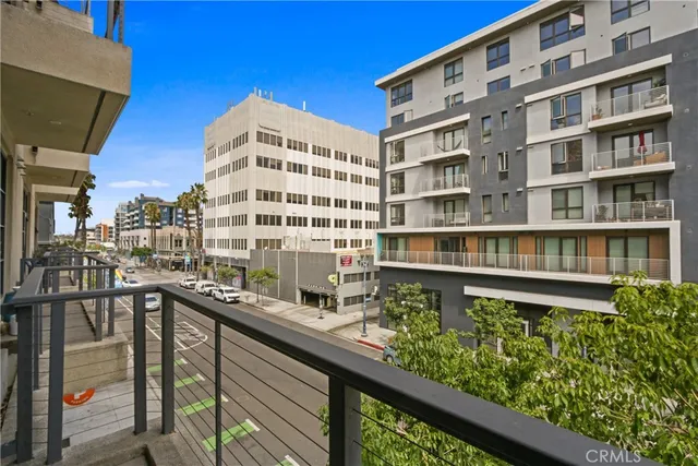a balcony view with a large window and outdoor seating