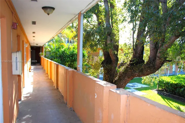 a view of a yard with plants and a bench