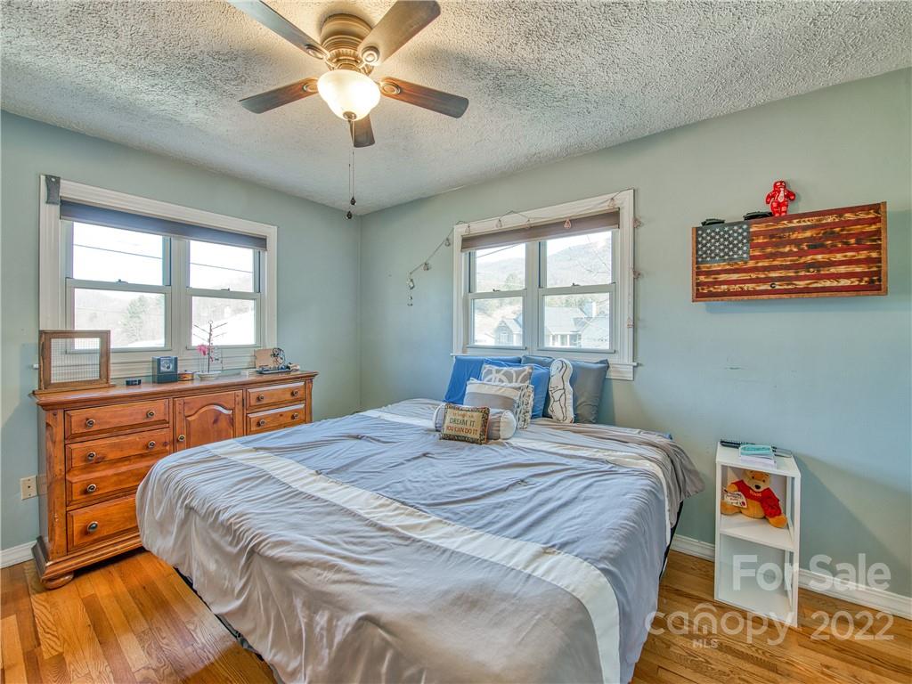 970 Ratcliff Cove Road Waynesville, NC 28786 - Photo 17 of 24 a bedroom with a bed and wooden floor